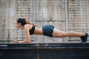 Young woman doing plank core work in urban setting