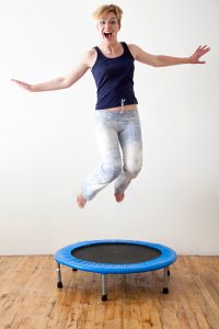 Caucasian woman jumping on indoor trampoline