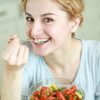 An image of a woman eating vegetable salad